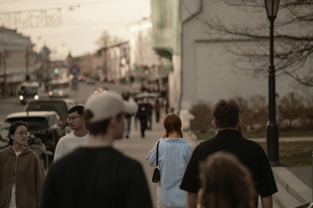 people waiting in line on city street